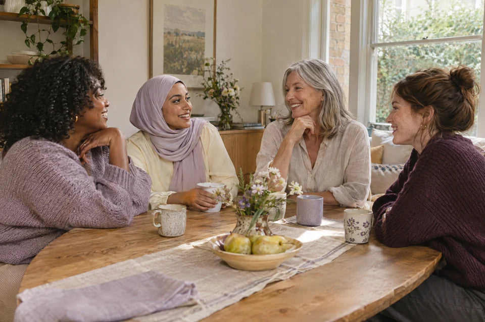 Illustrative campaign image of adult women of different ages talking around a table